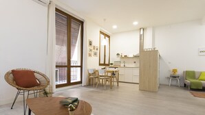 A modern living room with a dining area, a sofa, and a kitchen in the background. - Modern apartment in the historic center !!! (Zaragoza)