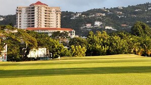 Un terrain de golf avec un grand bâtiment en arrière-plan.