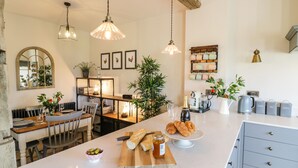 Eine moderne Küche mit Kochinsel, Holzmöbeln und Pendelleuchten.