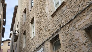 En smal gata med hus byggda av sten, vissa med gallerförsedda fönster och dörrar.