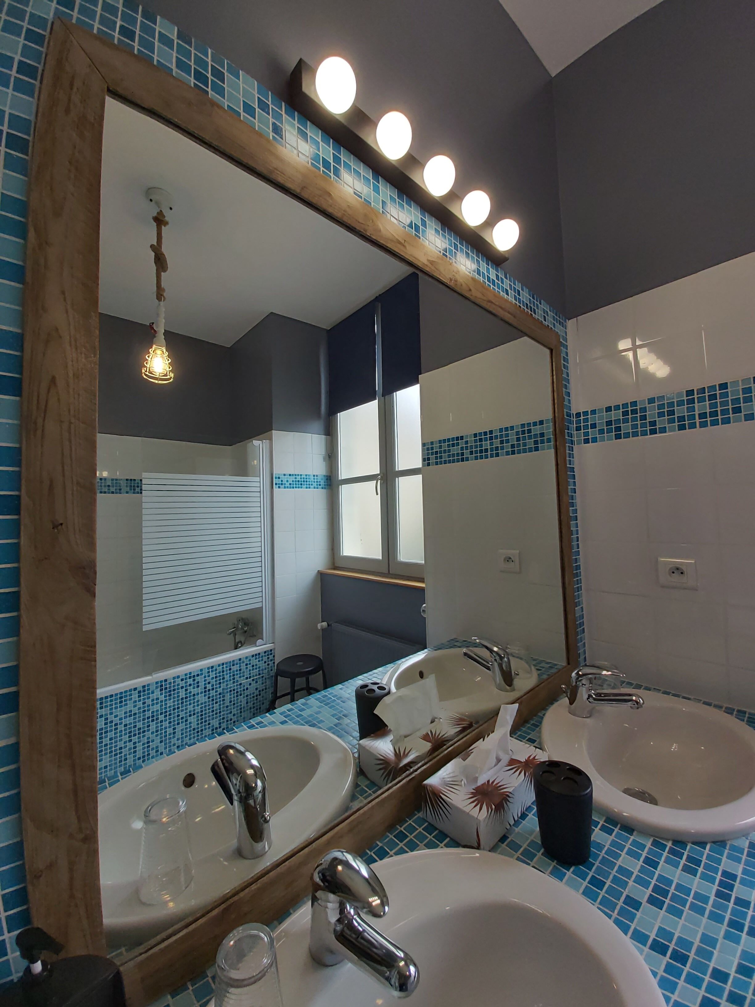 A bathroom with two sinks, a large mirror, and a window.