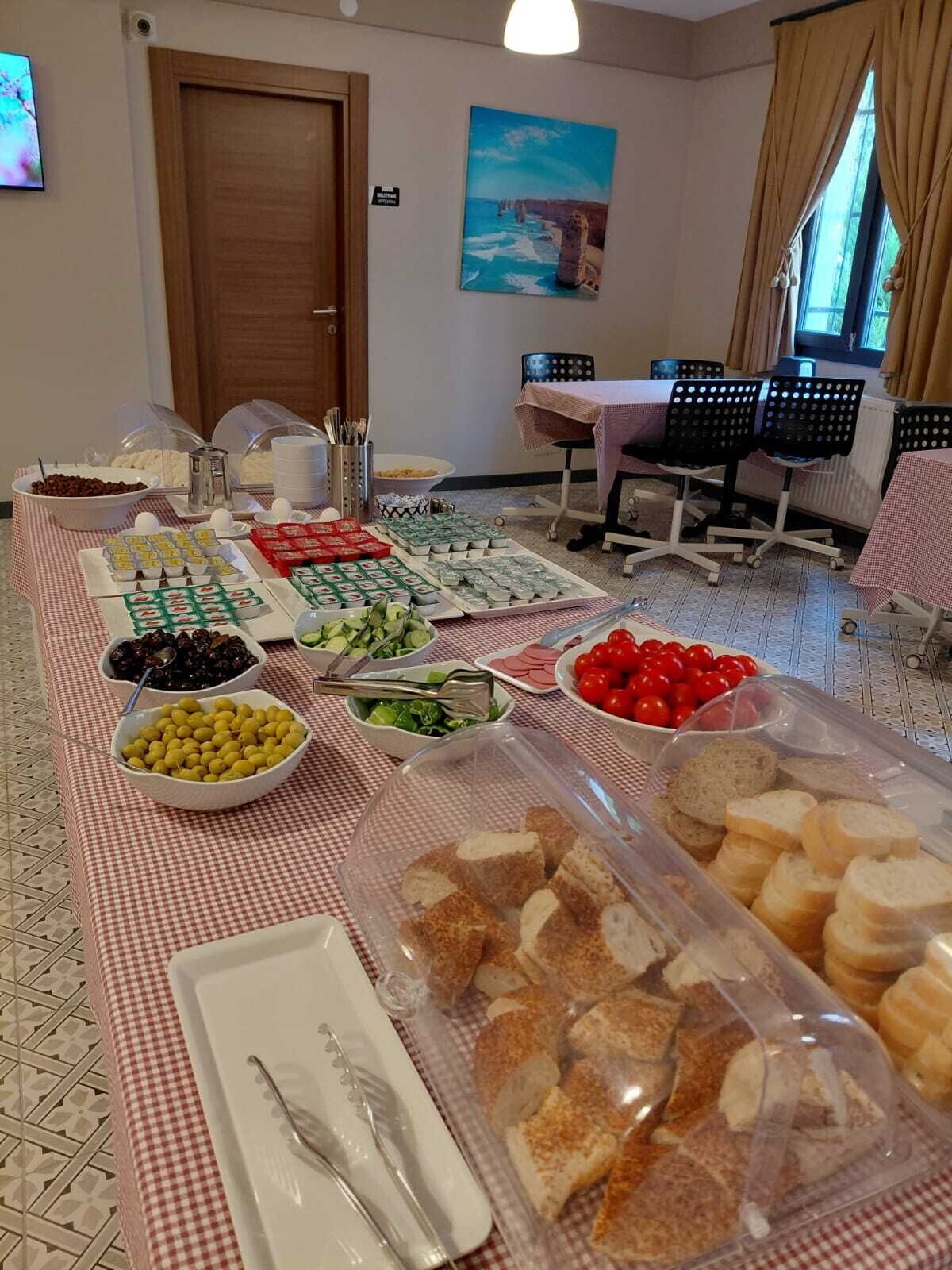 Un buffet de petit-déjeuner proposant une variété d’aliments et un espace repas avec des tables et des chaises.