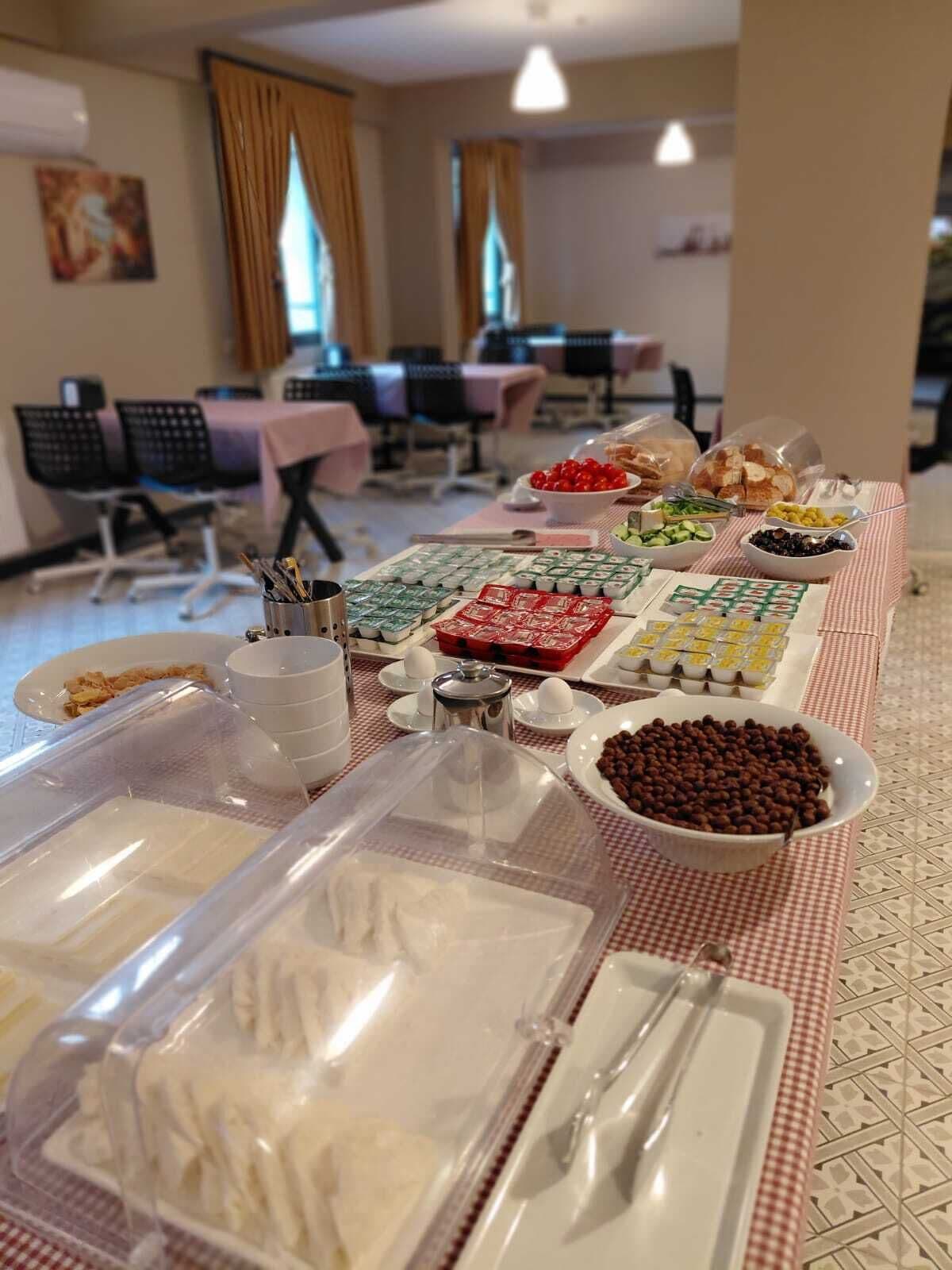 Un buffet garni de différents plats et couverts, le tout disposé sur une nappe à carreaux.