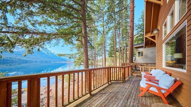 A wooden deck with a view of mountains and a lake. - Lakeside Retreat w/Private Sandy Beach and Hot Tub (Leavenworth)