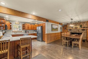 Una cocina amplia con armarios de madera, una isla central y una chimenea de piedra.