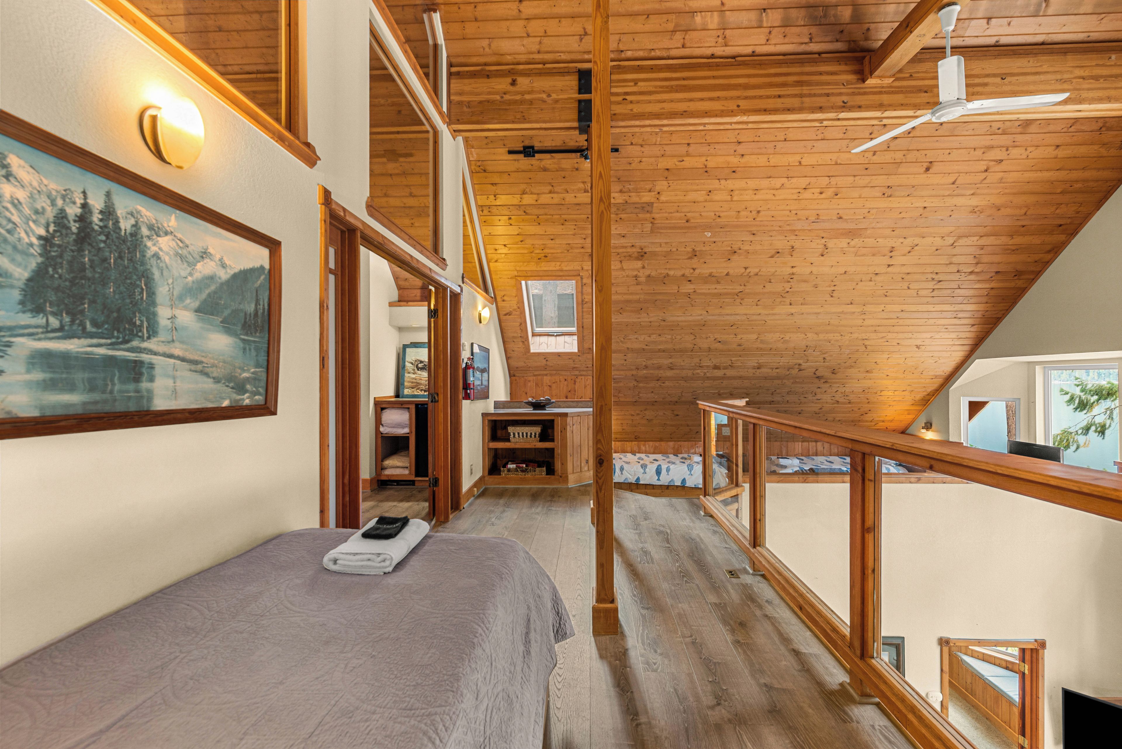 Une chambre à coucher avec un lit, un bureau et une fenêtre donnant sur un paysage enneigé.
