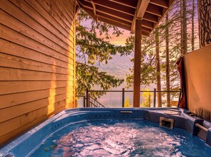 A hot tub with a wooden exterior, surrounded by trees and a view of mountains. - Lakeside Retreat w/Private Sandy Beach and Hot Tub (Leavenworth)
