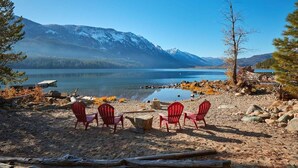 A lakeside view with mountains, red chairs, and a wooden dock. - Lakeside Retreat w/Private Sandy Beach and Hot Tub (Leavenworth)