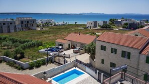 Relax by the pool surrounded by Mediterranean-style buildings and enjoy stunning sea views.