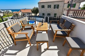 Enjoy a refreshing drink on the balcony overlooking the pool and surrounding architecture.