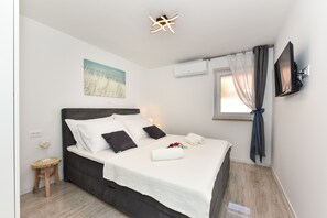 Cozy retreat with a large bed, bedside table, and flat-screen TV.