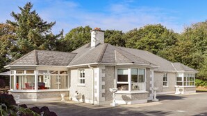 A two-story house with a covered porch, a chimney, and a driveway. - Woodlawn (Kilmore)