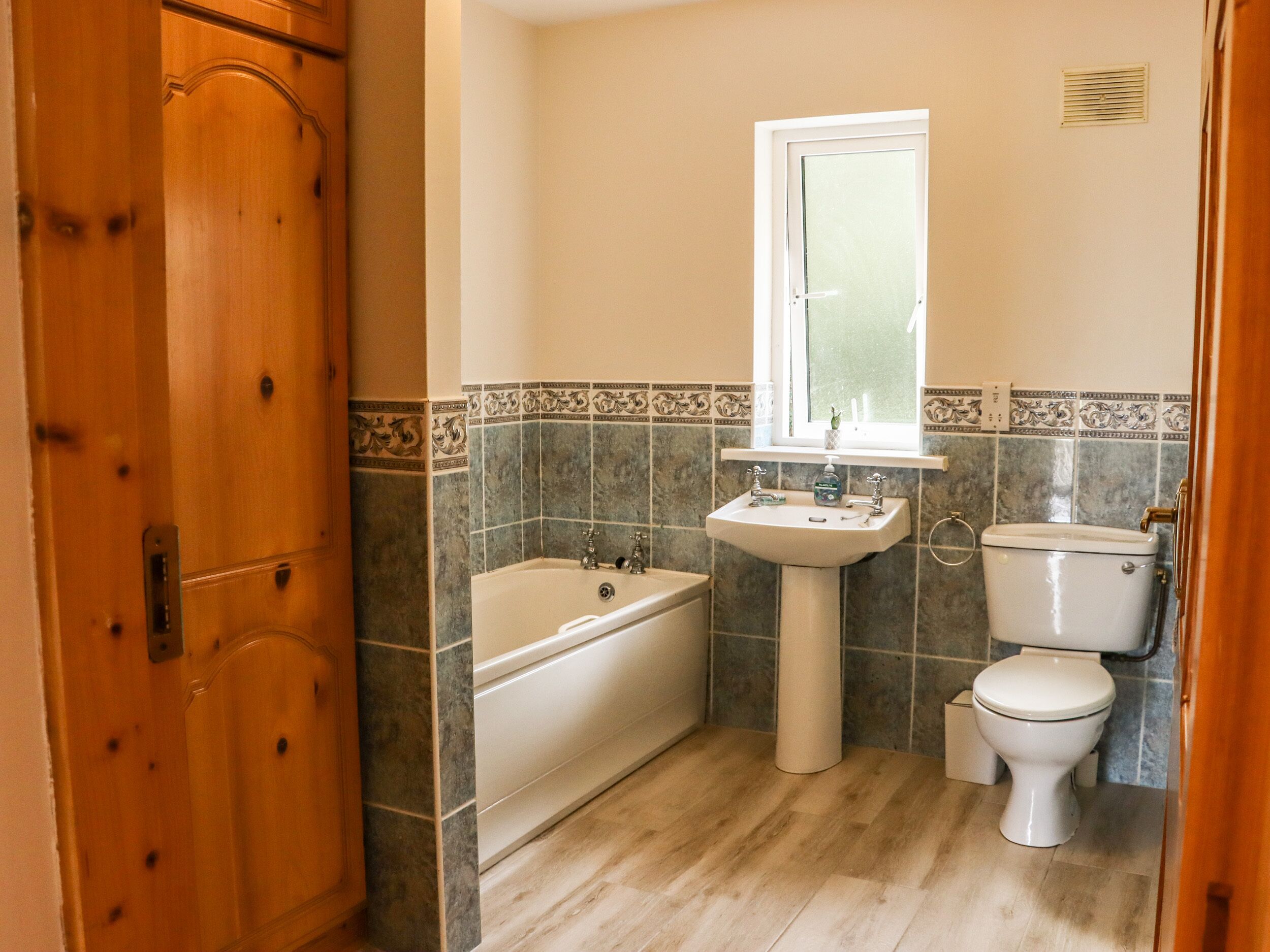 A bathroom with a bathtub, sink, and toilet.