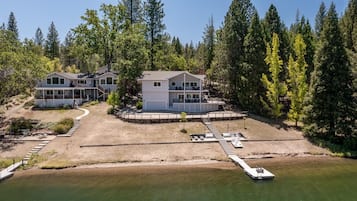 A lakeside property with multiple buildings, a dock, and a well-maintained lawn.