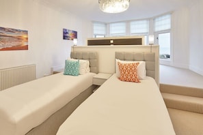 Een hotelkamer met twee bedden, een groot raam en uitzicht op de stad.