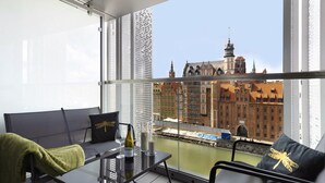 Een balkon met uitzicht op historische gebouwen en een rivier.
