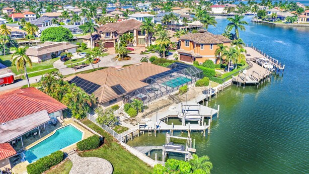 Un quartiere residenziale con case, una piscina e un molo che si protende in acqua.