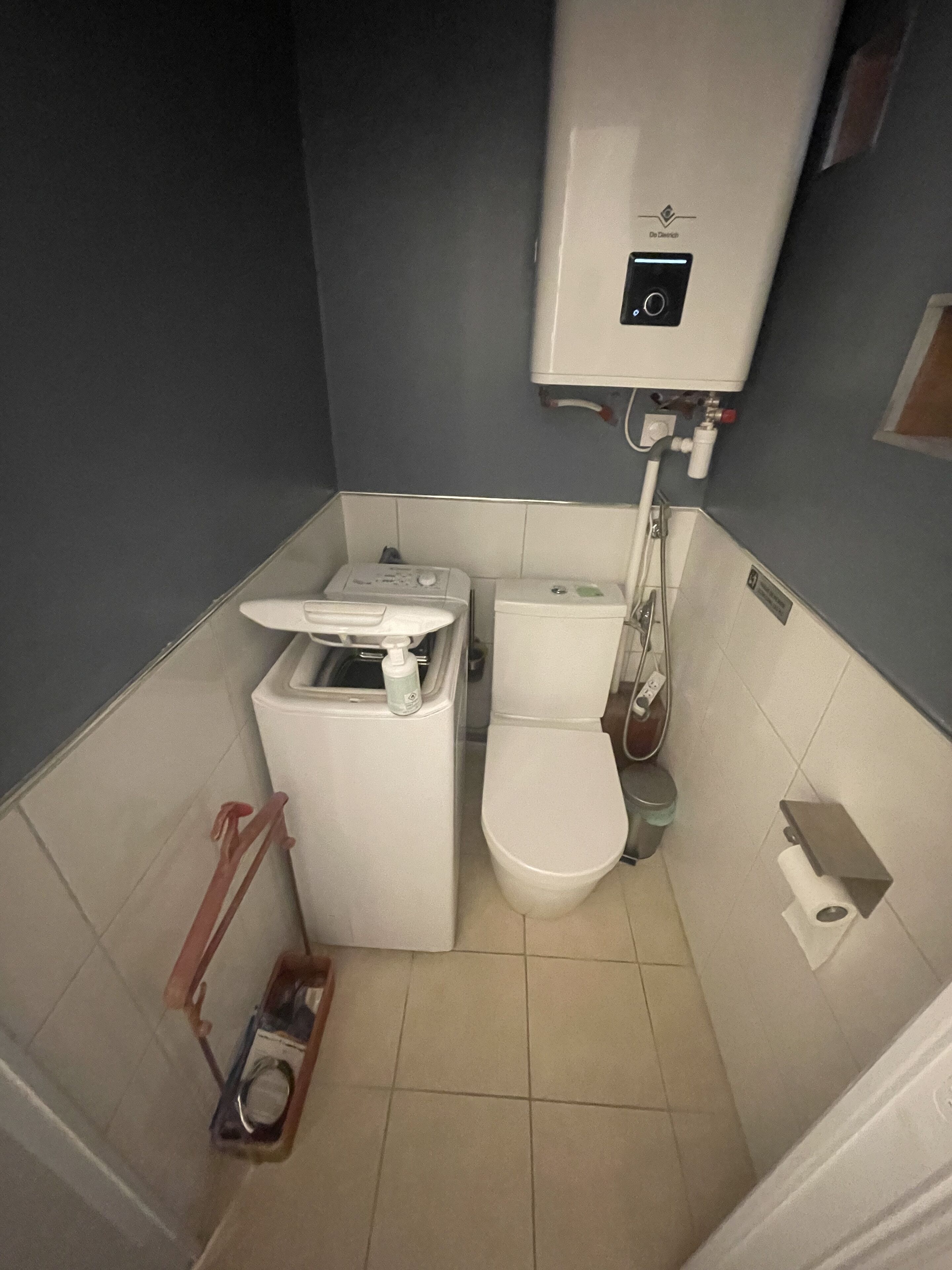 A compact bathroom with a toilet, bidet, and a small washing machine.