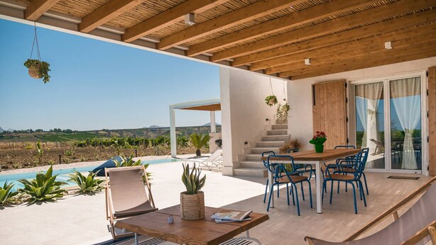 Eine moderne Terrassenanlage im Freien mit Pool, Holzmöbeln und Blick auf die Landschaft.