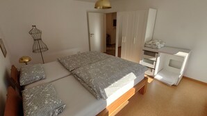Une chambre à coucher comprenant un lit, des tables de chevet, une armoire et un bureau.