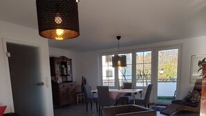 Un vaste espace de vie agrémenté d’une grande fenêtre, d’une table à manger et d’un coin salon confortable.
