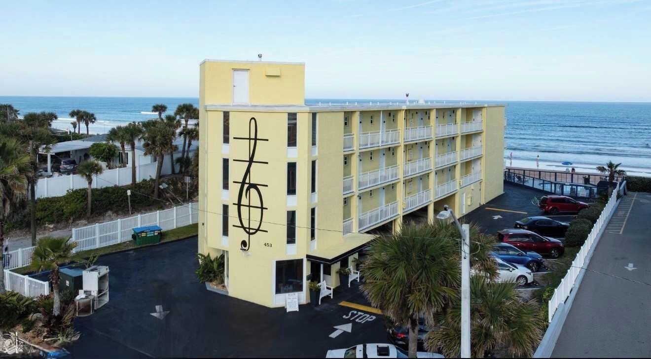 Un hôtel à plusieurs étages, doté d’un parking et offrant une vue sur l’océan.