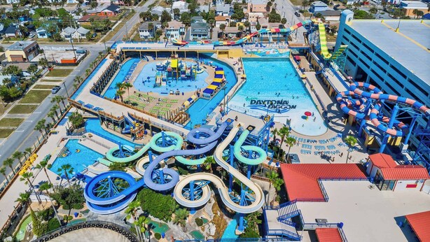 Ein Wasserpark mit mehreren Wasserrutschen und Pools, darunter ein großer Mittelpool und ein kleinerer Pool mit der Aufschrift 'DAYTONA MAGCON'.