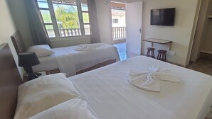 A hotel room with two beds, a TV, a small fridge, and a balcony with a view. - La Vega Pousada (Guapimirim)