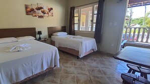 A hotel room with two beds, a small table, and a balcony with a view. - La Vega Pousada (Guapimirim)