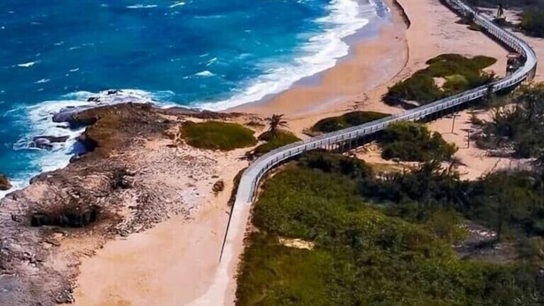 An aerial view of a coastal area with a curved road, beach, and forested land. - Tropical Private Beach Studio Apt #1 @ Jobos Beach (Jobos, Isabela, Puerto Rico)