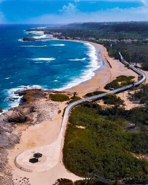 An aerial view of a coastal road with a beach and a bridge. - Tropical Private Beach Studio Apt #1 @ Jobos Beach (Jobos, Isabela, Puerto Rico)