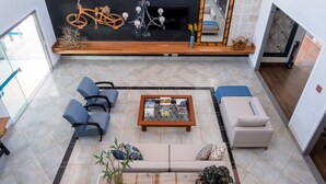 Un vaste espace de vie comprenant un canapé, une table basse et un coin salon avec des fauteuils.