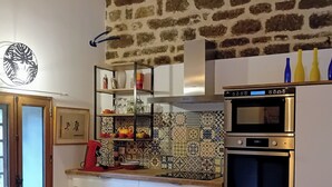 Eine Küche mit weißen Schränken, einem Doppelbackofen und einer gemusterten Spritzschutzwand.