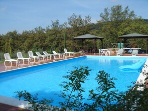 Alberca al aire libre y camastros 