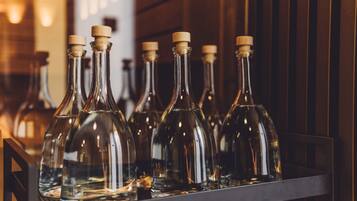 A row of empty wine bottles with corks on a shelf.