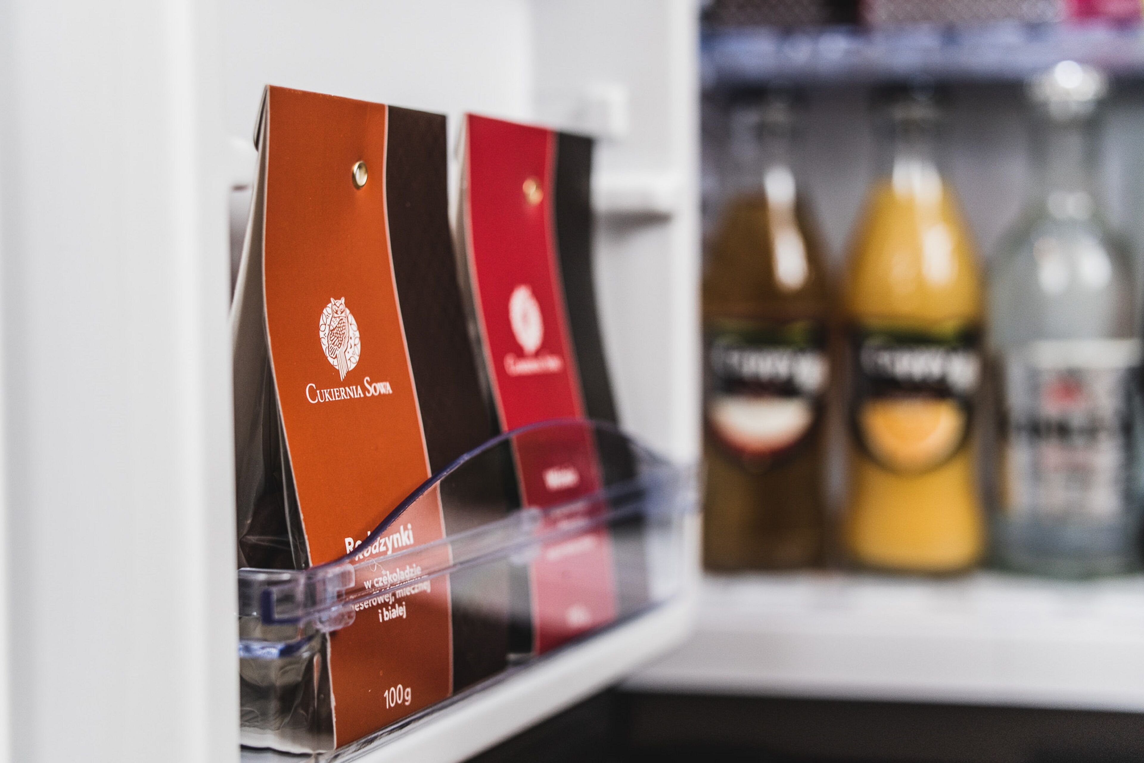 A refrigerator stocked with various beverages and packaged food items.
