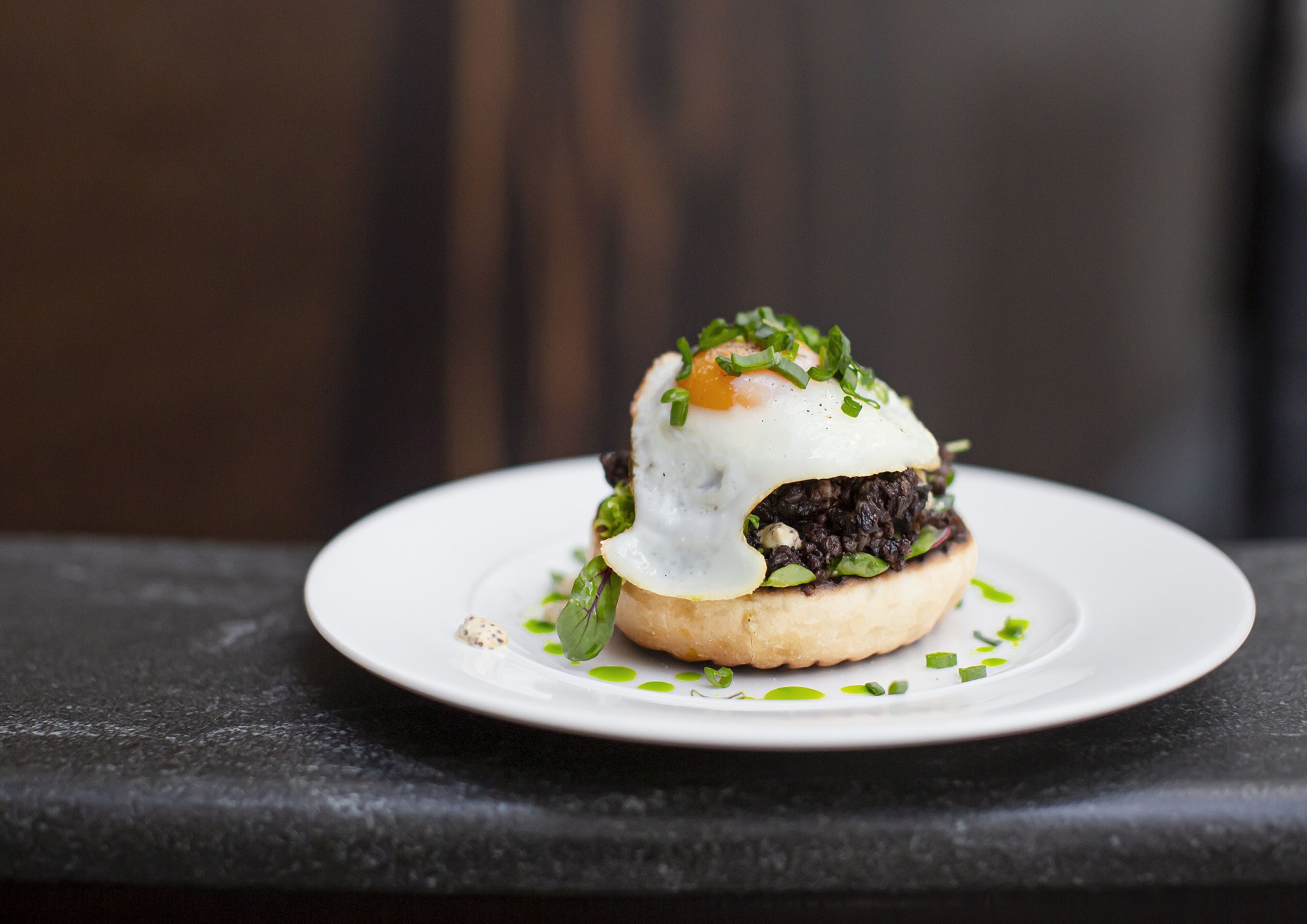 A sandwich on a white plate with a blurred background.