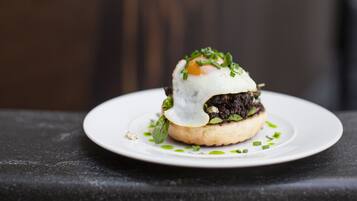 A sandwich on a white plate with a blurred background.