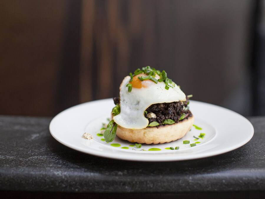 A sandwich on a white plate with a blurred background.