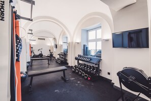 A gym with a bench, dumbbells, and a treadmill. - Rezydencja Sowa Bydgoszcz (Bydgoszcz)