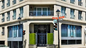 Un hôtel doté d’une façade moderne, d’une entrée imposante et d’une signalisation directionnelle.
