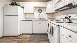 A modern kitchen with white cabinetry, a built-in dishwasher, a stove, and a microwave. - ◆ Sensational Apartment! 2 Bed 1 Bath - Sleeps 4 ◆ (Colorado Springs)