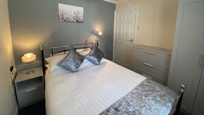 Une chambre à coucher avec un lit, une lampe de chevet et une porte.
