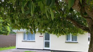 Un bâtiment blanc avec une enseigne indiquant « LANES END » et un arbre devant.
