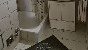 A bathroom with a shower, a sink, and a mirror. - Apartment  (Basilea)