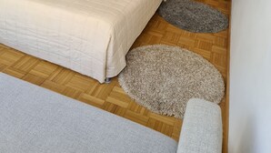 A bedroom with a large bed, a mirror, a chandelier, and a wooden door. - Apartment  (Basilea)