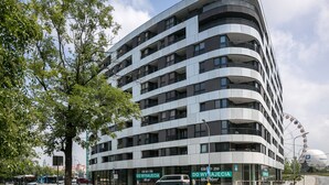 Un edificio a più piani con un design architettonico moderno, caratterizzato da balconi e ampie finestre.
