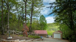 Une clôture en bois rustique, un bâtiment au toit rouge et un garage avec une porte en métal.
