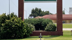 A large sign for The Heritage Inn with a brick pillar structure.