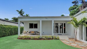 A modern house with a patio, a lawn, and a garden. - Renovated 4 Bedroom home, tastefully designed! (Miami)